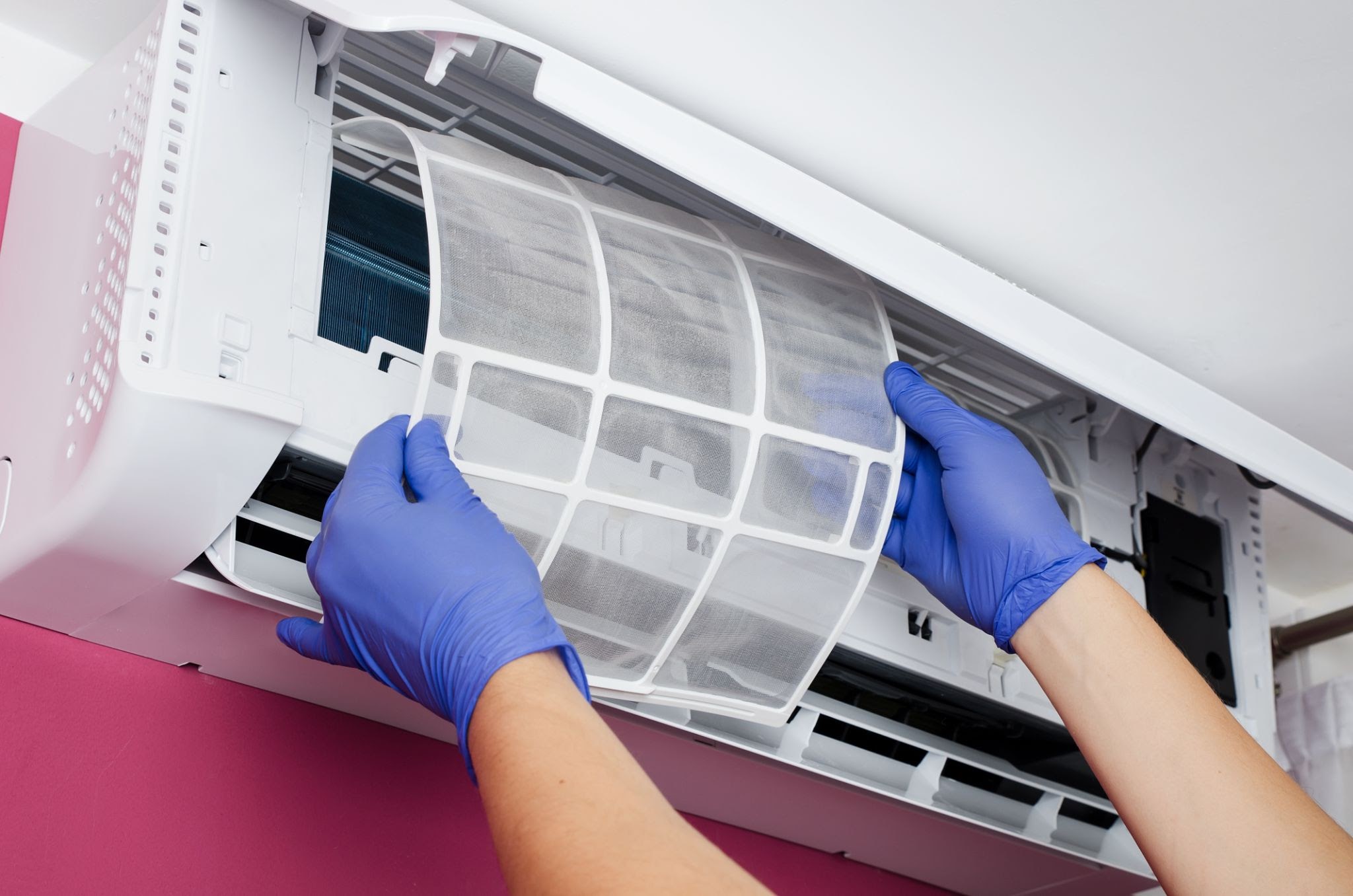 Air conditioner cleaning. Man in gloves checks the filter.